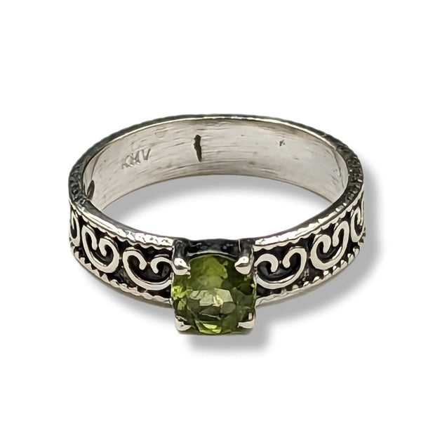Silver ring with green gemstone on a white background