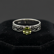 Silver ring with green gemstone on a black background