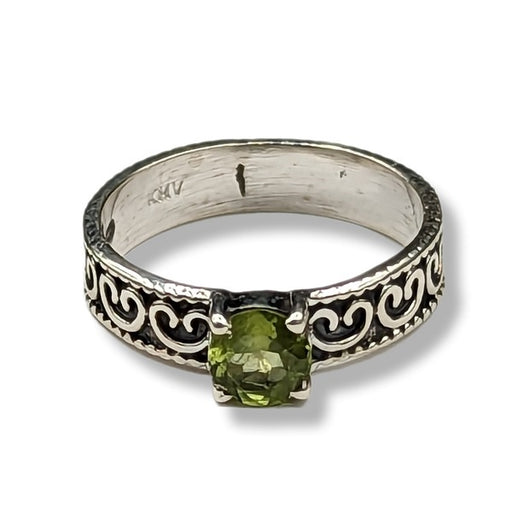 Silver ring with green gemstone on a white background