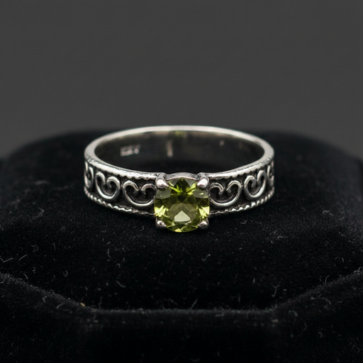 Silver ring with green gemstone on a black background
