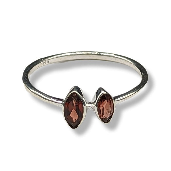 Silver ring with two red gemstones on a white background