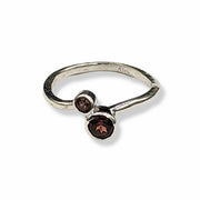 Silver ring with two brown gemstones on a white background