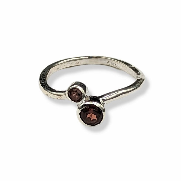 Silver ring with two brown gemstones on a white background