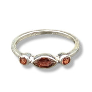 Silver ring with three brown gemstones on a white background