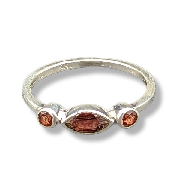 Silver ring with three brown gemstones on a white background