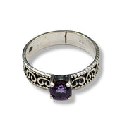 Silver ring with a purple gemstone on a white background