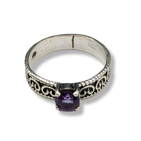 Silver ring with a purple gemstone on a white background