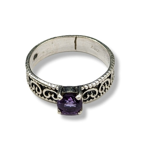 Silver ring with a purple gemstone on a white background