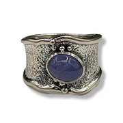 Silver ring with a blue stone on a white background