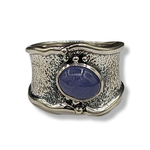 Silver ring with a blue stone on a white background