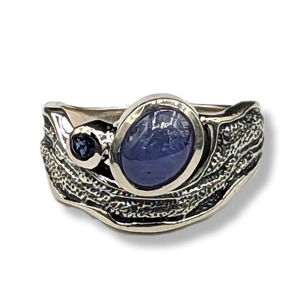 Silver ring with blue gemstone on a white background