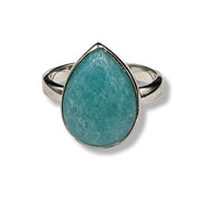 Teardrop-shaped turquoise stone ring with silver band on a white background