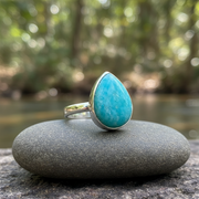 Turquoise teardrop ring on a stone with a blurred natural background