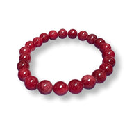 A beaded stretch bracelet made of polished, round red gemstone beads, displayed on a clean white background with a soft drop shadow.