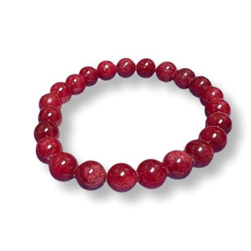 A beaded stretch bracelet made of polished, round red gemstone beads, displayed on a clean white background with a soft drop shadow.