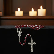 Glass Birthstone Rosary for July with candles in the background