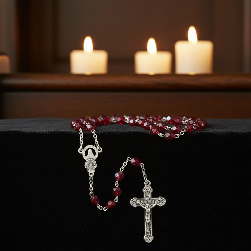 Glass Birthstone Rosary for July with candles in the background