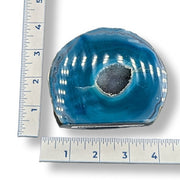 A polished agate geode slice with a dark gray druzy center, shown with ruler measurements on the left and bottom edges to indicate size.
