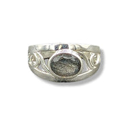 Silver ring with intricate design on a white background