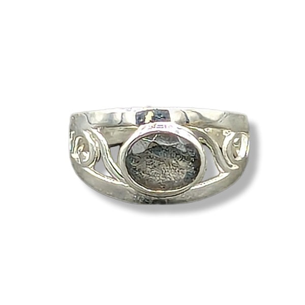 Silver ring with intricate design on a white background
