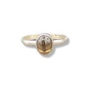 A sterling silver ring with a grey stone on a white background