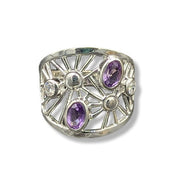 Silver ring with purple gemstones on a white background