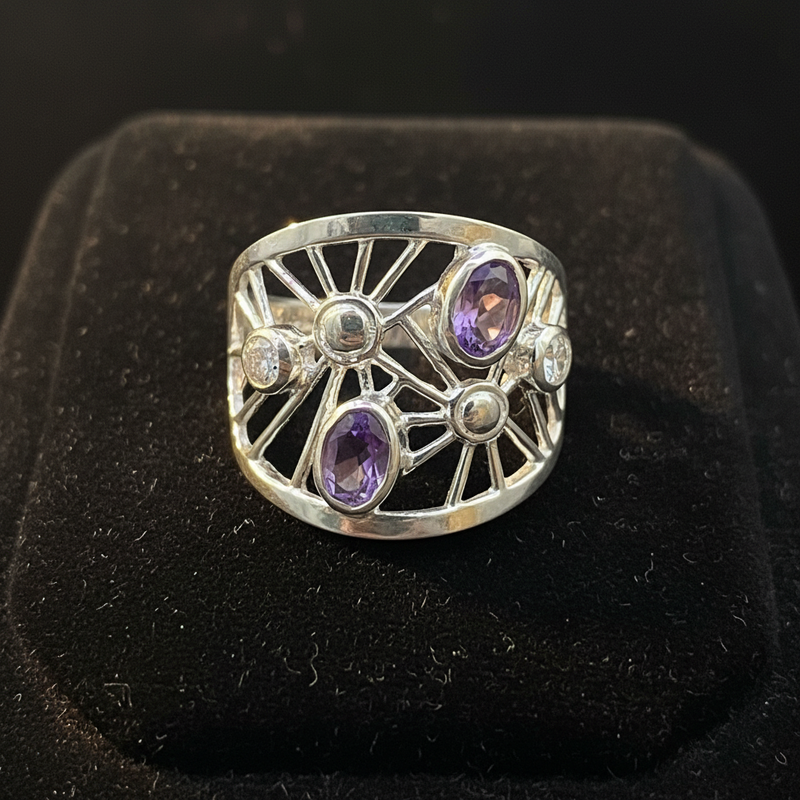 Silver ring with purple gemstones on a black background