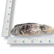 Amethyst crystal next to a ruler on white background