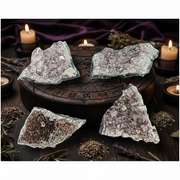Crystal rocks on a wooden surface with candles and herbs in the background