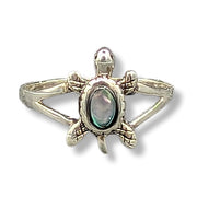 Silver turtle-shaped ring with a central gemstone on a white background