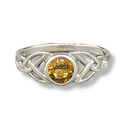 Silver ring with a yellow gemstone on a white background