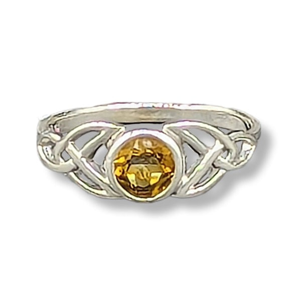 Silver ring with a yellow gemstone on a white background