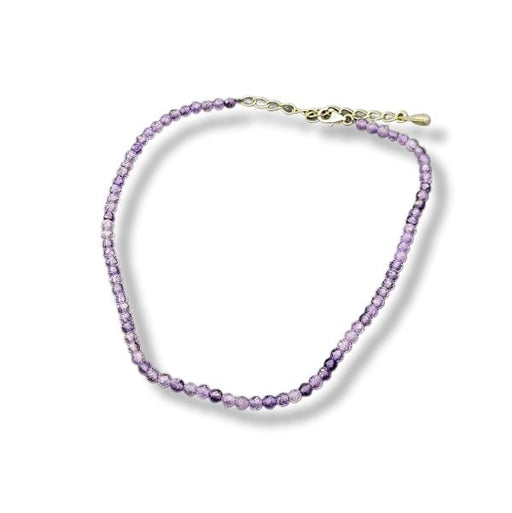 Purple beaded anklet with a gold clasp on a white background