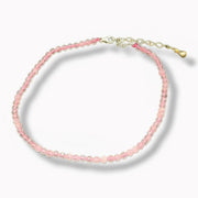 Pink beaded anklet with a gold clasp on a white background