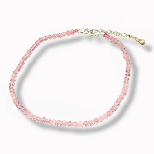 Pink beaded anklet with a gold clasp on a white background
