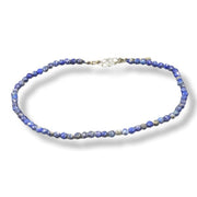 Blue beaded anklet on a white background