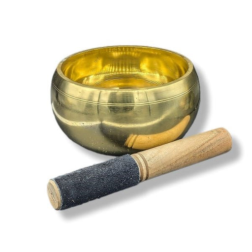 Singing bowl with wooden beater on a white background