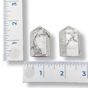 Two Howlite towers next to a ruler on a white background
