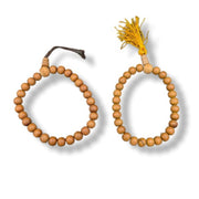 Wooden beaded bracelets with tassels on a white background