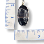 Oval-shaped pendant with sterling silver  on a white background with ruler for scale