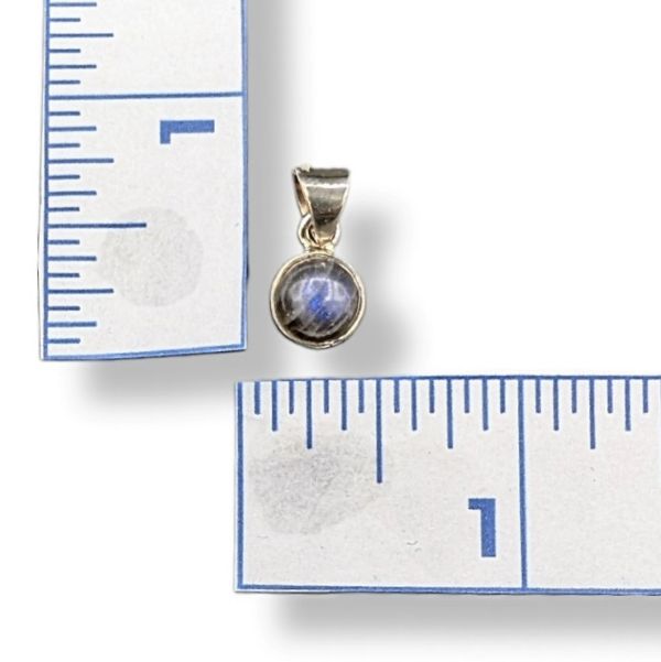 Small pendant with a gemstone next to a ruler on a white background