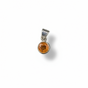 Silver pendant with a round orange stone on a white background