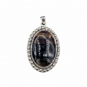 Silver pendant with a dark stone on a white background