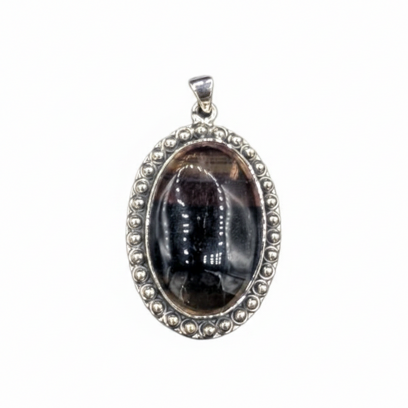 Silver pendant with a dark stone on a white background