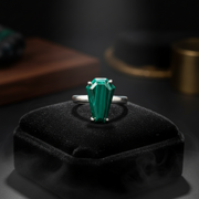 A sterling silver malachite ring resting on a black pillow