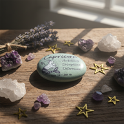 Decorative stone with Capricorn zodiac sign surrounded by crystals and stars on a wooden surface