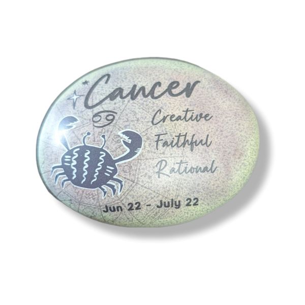 Round stone with Cancer zodiac design, crab illustration, and descriptive text on a light background