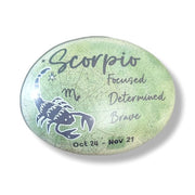 Round stone with Scorpio zodiac design on a white background