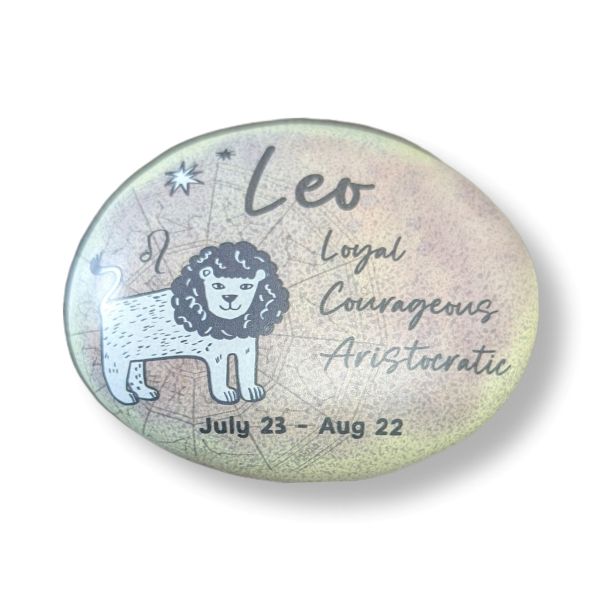 Round stone with Leo zodiac design, lion illustration, and descriptive text on a light background