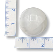White spherical selenite next to a ruler on a white background